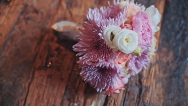 Wedding bouquet lying on a wooden surface — Stock Video