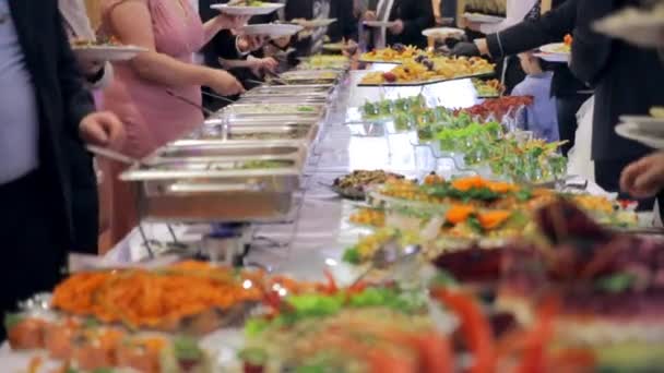 Гости ресторана выбирают блюда из шведского стола — стоковое видео