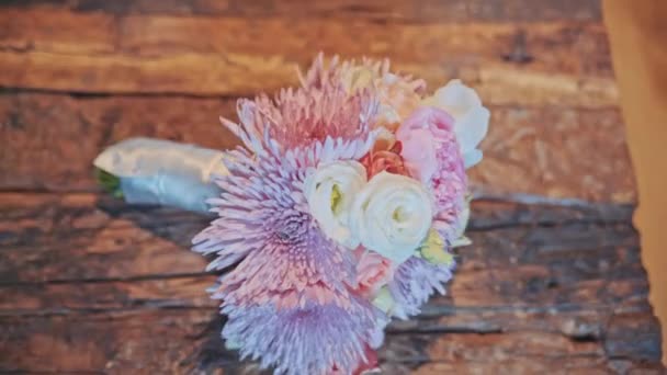 Wedding bouquet lying on a wooden surface — Stock Video