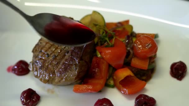 De chef-kok ingericht de steak met geroosterde groenten. Slow motion — Stockvideo