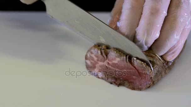 La carne es cortada en el tablero blanco. Movimiento lento — Vídeos de Stock