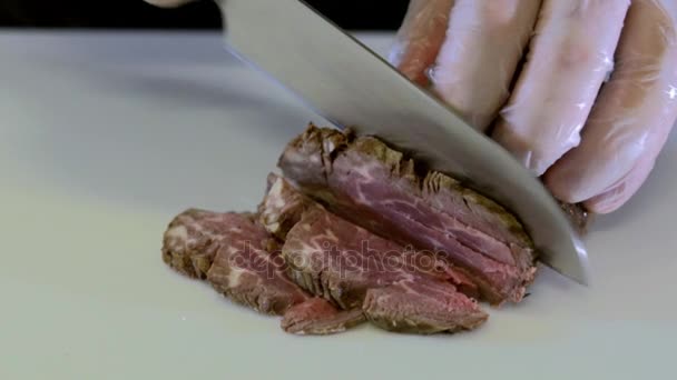 Мясо режут на белой доске. Медленное движение — стоковое видео