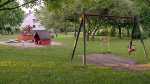 Um parque infantil vazio com baloiços — Vídeo de Stock