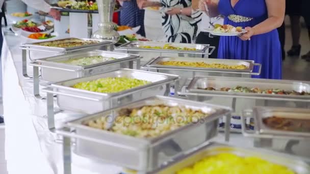 Прием: люди навязывают еду в блюде — стоковое видео