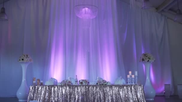 Красивий прикрашений зал для весілля в фіолетовому світлі — стокове відео