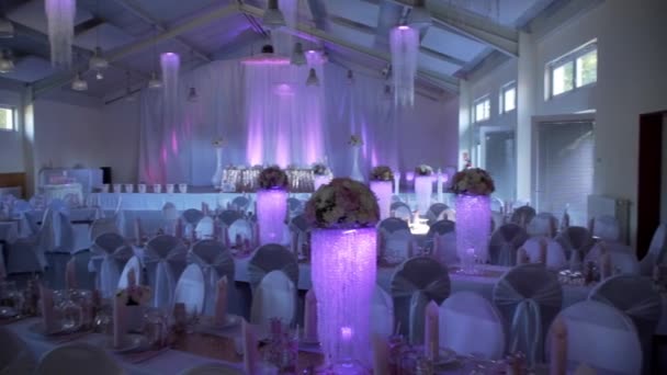 Красивий прикрашений зал для весілля в фіолетовому світлі — стокове відео