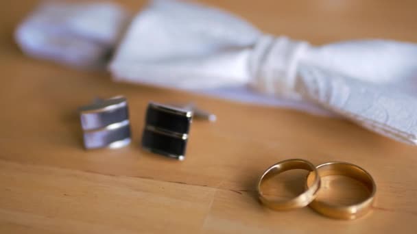 Γαμήλιο δαχτυλίδι, παπιγιόν και μανικετόκουμπα είναι στο τραπέζι — Αρχείο Βίντεο
