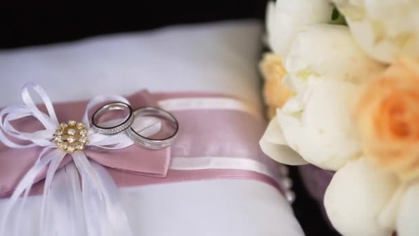Esküvői csokor és a gyűrűk a fekete háttér — Stock videók