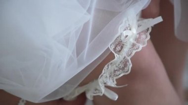 Gelin bir jartiyer bacak giyer.