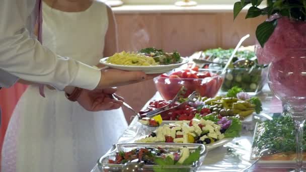Buffé: människor tar mat i skålen — Stockvideo