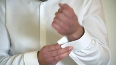 Adam kol düğmeleri beyaz gömlek kapatır