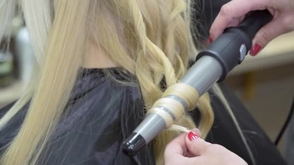 Cabeleireiro faz cabelo loiro de mulher jovem — Vídeo de Stock