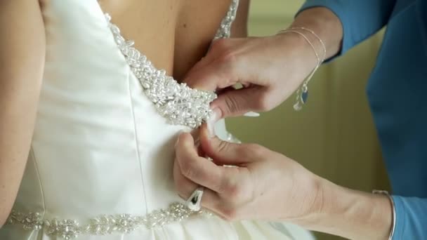 Brides beautiful back in fantastic white wedding dress and hands zipping it — Stock Video