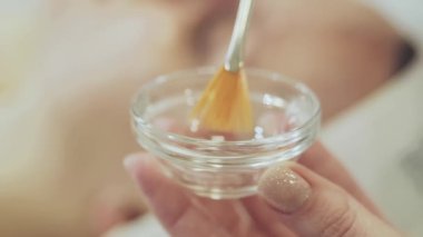 Güzellik uzmanı ilacı fırçayla karıştırıyor.