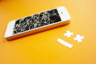 Üzgün bir gülümseme ile turuncu arka plan üzerinde kırık tahrip ekran ile Kırık smartphone. Kırık telefon hizmeti, kurtarma ve onarım sembolü yan görünüm.