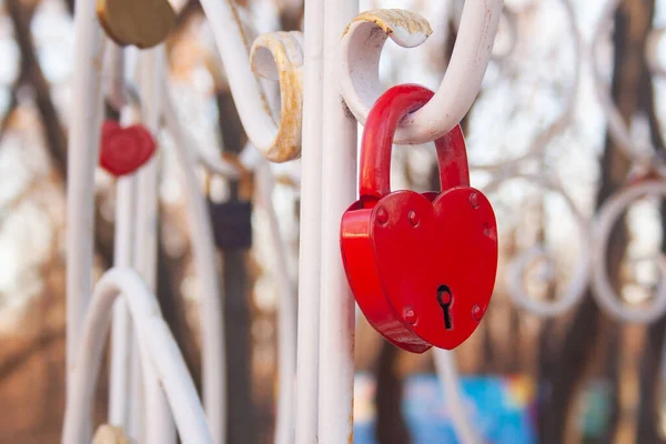 赤いハートロック バレンタインの愛のシンボル 赤いハートロックの白いフェンスにかかって — ストック写真