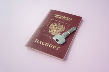 Pembe arka planda ıvır zıvır evi olan Rus uluslararası pasaportu ve anahtarı fotokopi alanını kapatın. Göçmenlik, göç, vatandaşlık kavramı