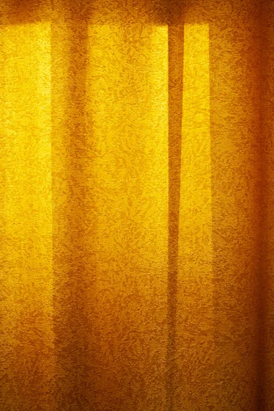 Red curtain background in sunset light. Curtain cloth texture dark vertical