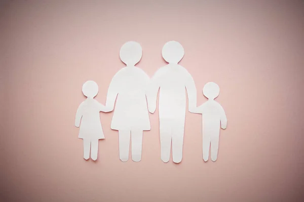 paper family cut out on bright pink background, family home, foster care, family mental health, homeschool education concept.