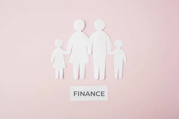 paper family cut out on bright pink background, family home, foster care, family mental health, budget and money concept. Paper family with phrase quote finance