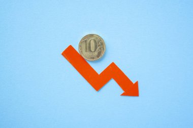 Mavi arka planda on rublelik para ve kırmızı ok. Döviz kuru çizelgesi. Ruble değer kaybı. Karşılıklı düşüş oranı. Dolara dönüş