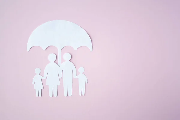 Concept of Social Protection Family. Paper cut Family Under Umbrella on bright pink background. Life insurance, family protection