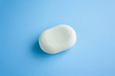 Mavi arka planda sabun manzarası ve güneşten gelen son moda ışıklandırma. Ellerini yıka. Bakteri ve virüslere karşı sabun. Koronavirüsle savaşmak için hijyen ve kısırlığa uyum.