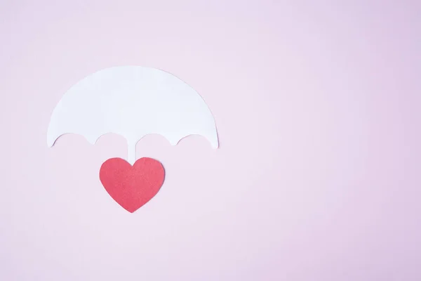 Red paper heart shape under white paper umbrella as life, health insurance concept. Assurance. insurance life symbol