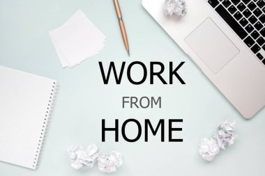 Ev konsepti dizüstü bilgisayar, not defteri, buruşmuş kağıt ve kalem kaplamalı düz görünüm fotosu. Coronavirüsü durdurmak için evde kal.