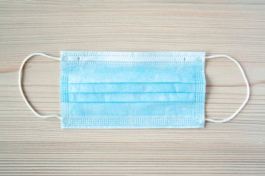 Bakteri ve virüslere karşı ahşap sırtında tek kullanımlık tıbbi maske. Koronavirüsün yayılmasını engelle, nefsi müdafaa. Boşluğu kopyala
