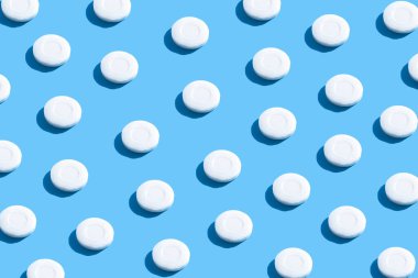 Modaya uygun güneş ışığıyla mavi arka planda duran katı sabun deseni. Ellerini yıka. Bakteri ve virüslere karşı sabun. Koronavirüsle savaşmak için hijyen ve kısırlığa uyum.