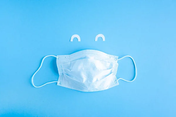 Disposable Medical Mask Blue Background White Paper Eyes Smiling Cut — Stock Photo, Image