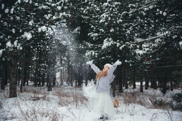 Menina brincando com a neve na floresta — Fotografia de Stock