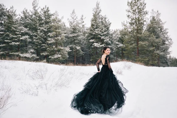 Νύφη μέσα στο δάσος του χειμώνα σε ένα μαύρο φόρεμα — Φωτογραφία Αρχείου