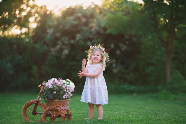 Flicka som leker på gräsmattan med blommor — Stockfoto