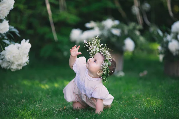 Girl playing on the lawn with flowers — Stock Photo, Image