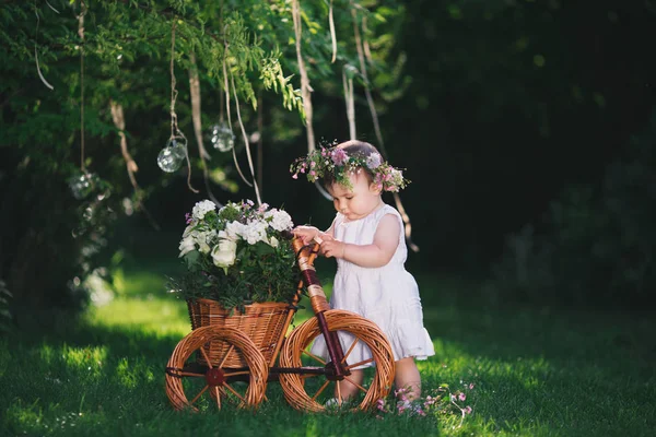 Flicka som leker på gräsmattan med blommor — Stockfoto