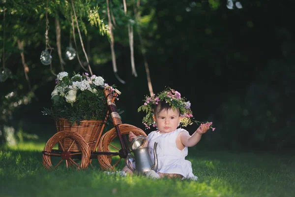 Fille jouer sur la pelouse avec des fleurs — Photo