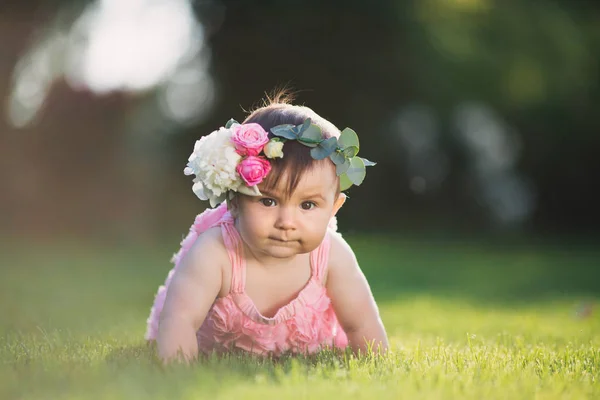 Chica jugando en el césped con flores —  Fotos de Stock