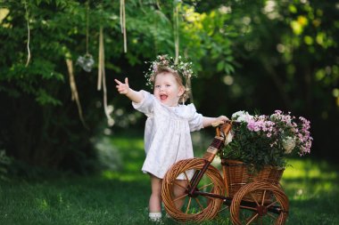 Çiçekli bir çimenlikte gülen kız