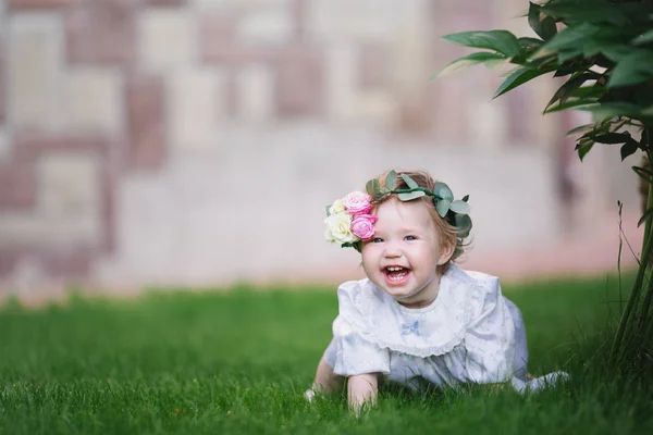 หัวเราะสาวบนสนามหญ้ากับดอกไม้ — ภาพถ่ายสต็อก