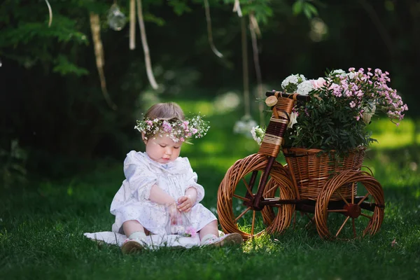 Girl playing on the lawn with flowers — Stock Photo, Image