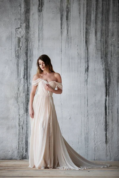 Modemodel in een prachtige beige vloeiende jurk. Wedding concept. — Stockfoto