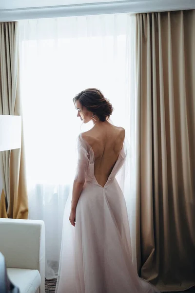 Portrait of the bride with open dress from the back. Open back. Beautiful neckline on the dress. sexy back