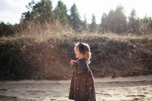 Nettes kleines Mädchen in dunklem Kleid weint im herbstlichen Wald. Ungehorsam. Seitenansicht — Stockfoto