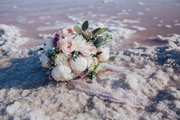 ช่อดอกไม้เจ้าสาวที่สวยงามของดอกกุหลาบสีขาว, ดอกโบตั๋นและยูคาลิปตัสและลูกไม้บนชายหาดทะเล . — ภาพถ่ายสต็อก