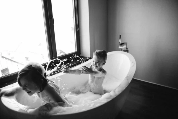 浴室には子供たちの白黒写真が飛び散っています。楕円形の風呂 — ストック写真