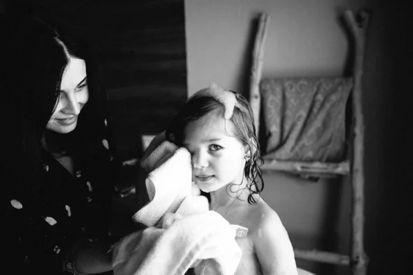 The little girl and mom wiping her face after taking the bath Stock Image