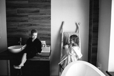 Two kids brother and sister in unicorn bathrobes after having bath