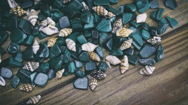 Malachite on wooden background, small shells on a wooden backgro clipart